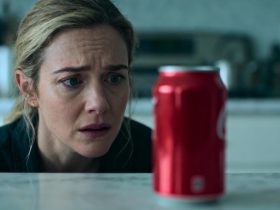 Femme européenne préoccupée regardant une canette de coca-cola posée sur un plan de travail de cuisine