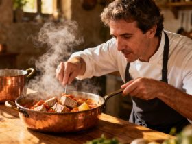 Chef européen préparant un marmitako, ragoût de thon basque, dans une cuisine rustique avec des ingrédients frais