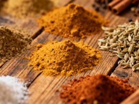 Chef européen préparant des alternatives au curry sur une table en bois rustique, avec des épices disposées en petits bols